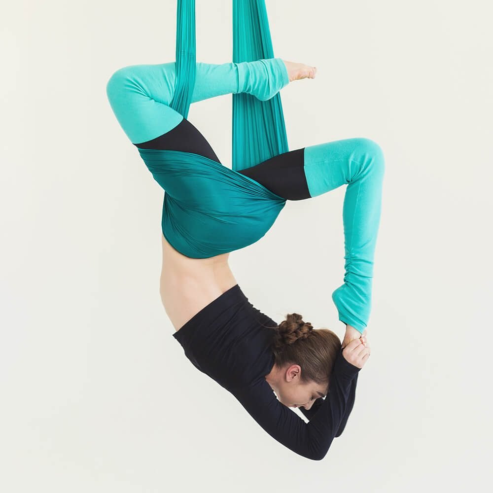woman-practicing-fly-yoga-over-white-background-PJSNDLR.jpg